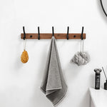 Détail des crochets en bois noir du porte manteau mural