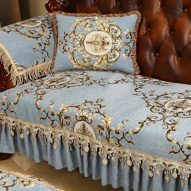Un élégant couvre-lit en velours bleu ciel décoré de motifs floraux dorés, avec des franges dorées sur les côtés, crée une atmosphère de luxe et de raffinement dans la chambre.