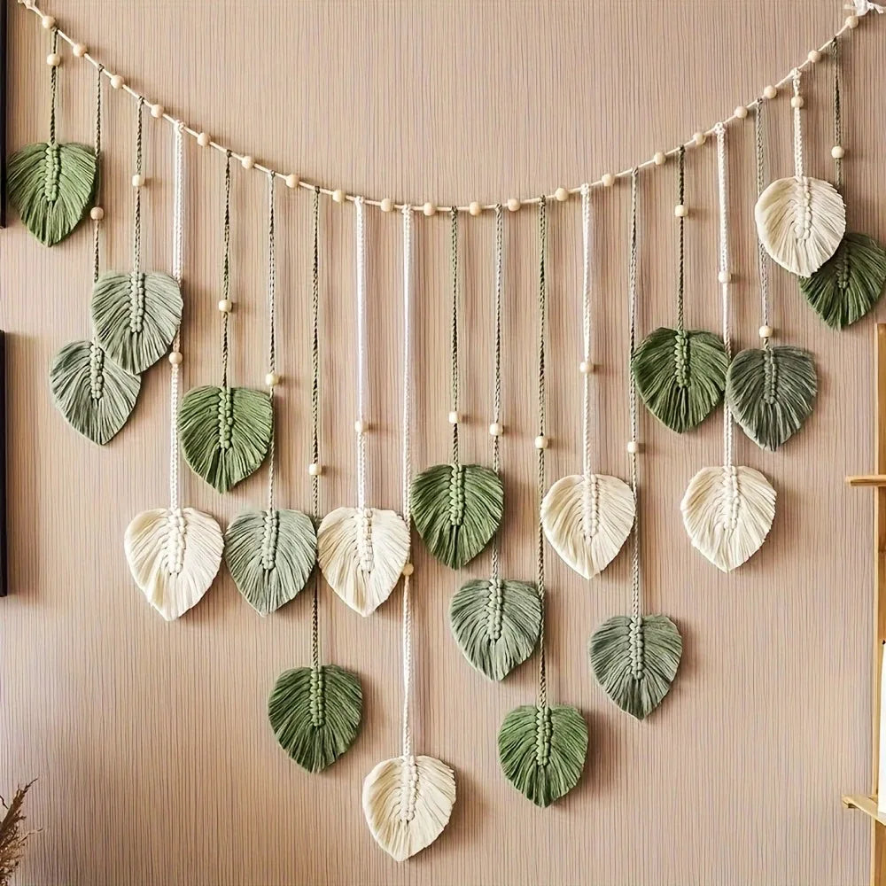Plume en macramé suspendue abricot sur mur blanc