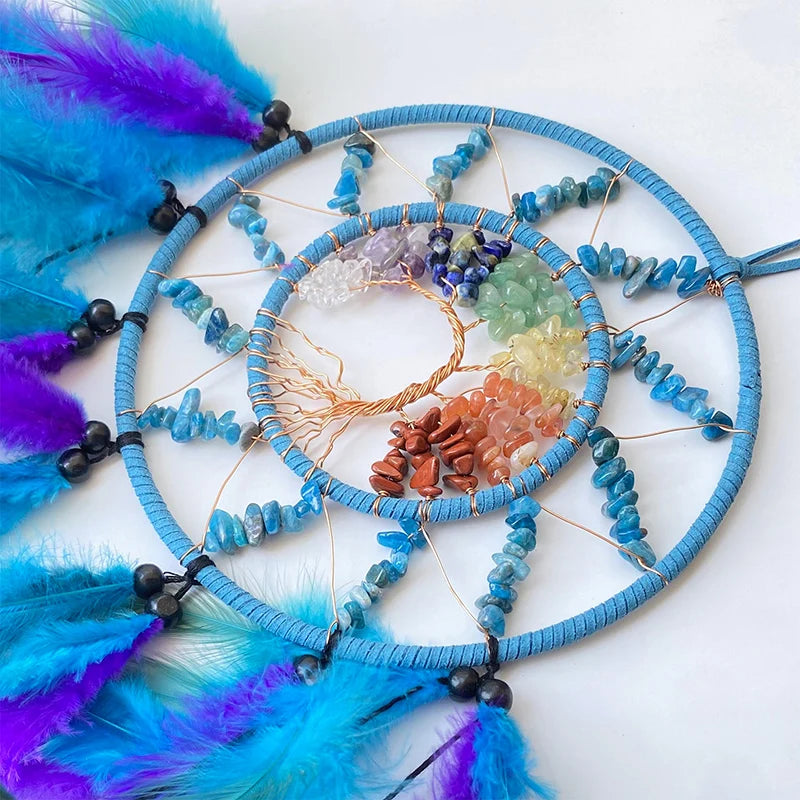 Un capteur de rêves aux accents ethniques, composé d'un cercle de perles de turquoise, de pierres semi-précieuses colorées et de plumes violettes et bleues.