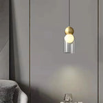 Lampe suspendue grise au-dessus d'une table de chevet