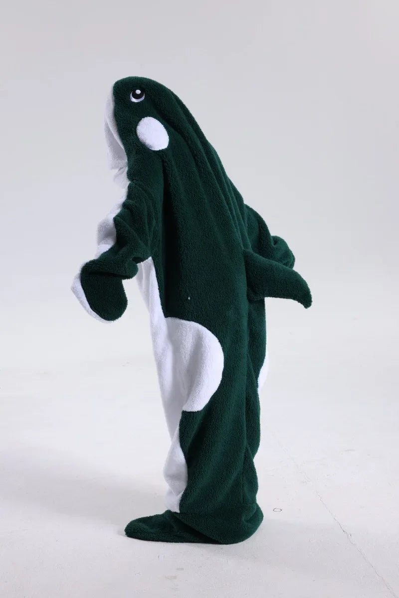Un jouet en peluche représentant un petit poulpe vert avec des détails blancs, debout sur un fond blanc.