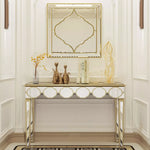 Un meuble console élégant en métal doré avec un miroir décoratif assorti, orné de figurines et d'accessoires dans un style contemporain raffiné.