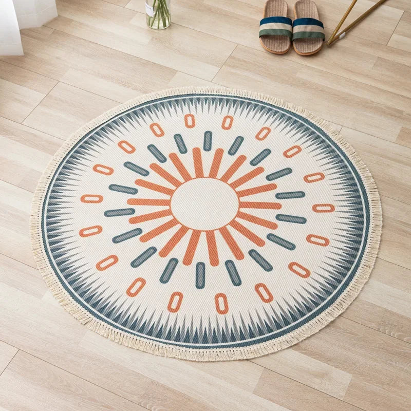 Un tapis rond en fibres naturelles avec un motif soleil stylisé en gris et orange, créant une ambiance chaleureuse et harmonieuse dans la pièce.