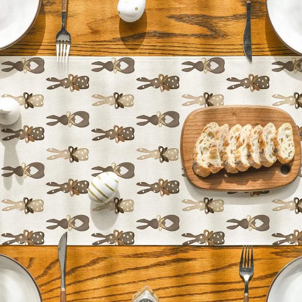 Sur une table en bois, on peut voir une assiette avec des tranches de pain et des ustensiles de cuisine, sur un fond décoré de motifs de bestioles en chocolat.