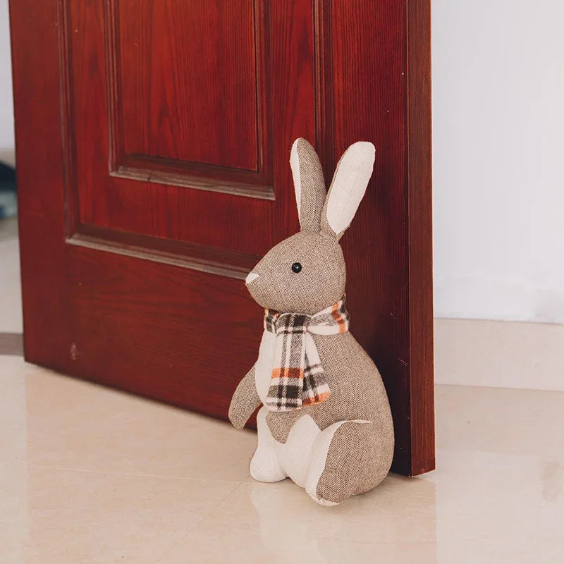 Cale-porte lapin en peluche gris clair sur sol carrelé
