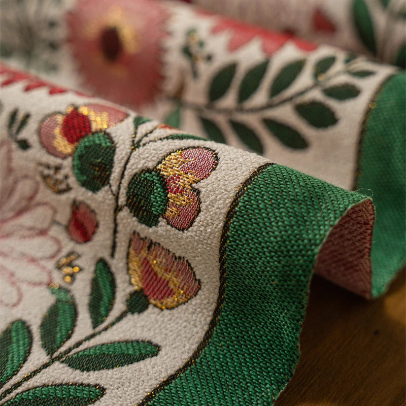 L'image montre un beau tissu orné de motifs floraux colorés, avec des feuilles et des fleurs aux teintes chaudes. Le textile présente un design exotique et décoratif qui évoque une atmosphère chaleureuse et naturelle.