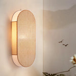 Détail de l'applique murale en rotin naturel, design artisanal pour chambre