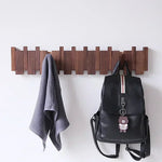 Porte-manteau mural en bois massif perforé noir accroché dans un salon contemporain