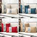Élégants coussins décoratifs bleus, rouges et beiges ornés de motifs floraux traditionnels sur un canapé en tissu clair.