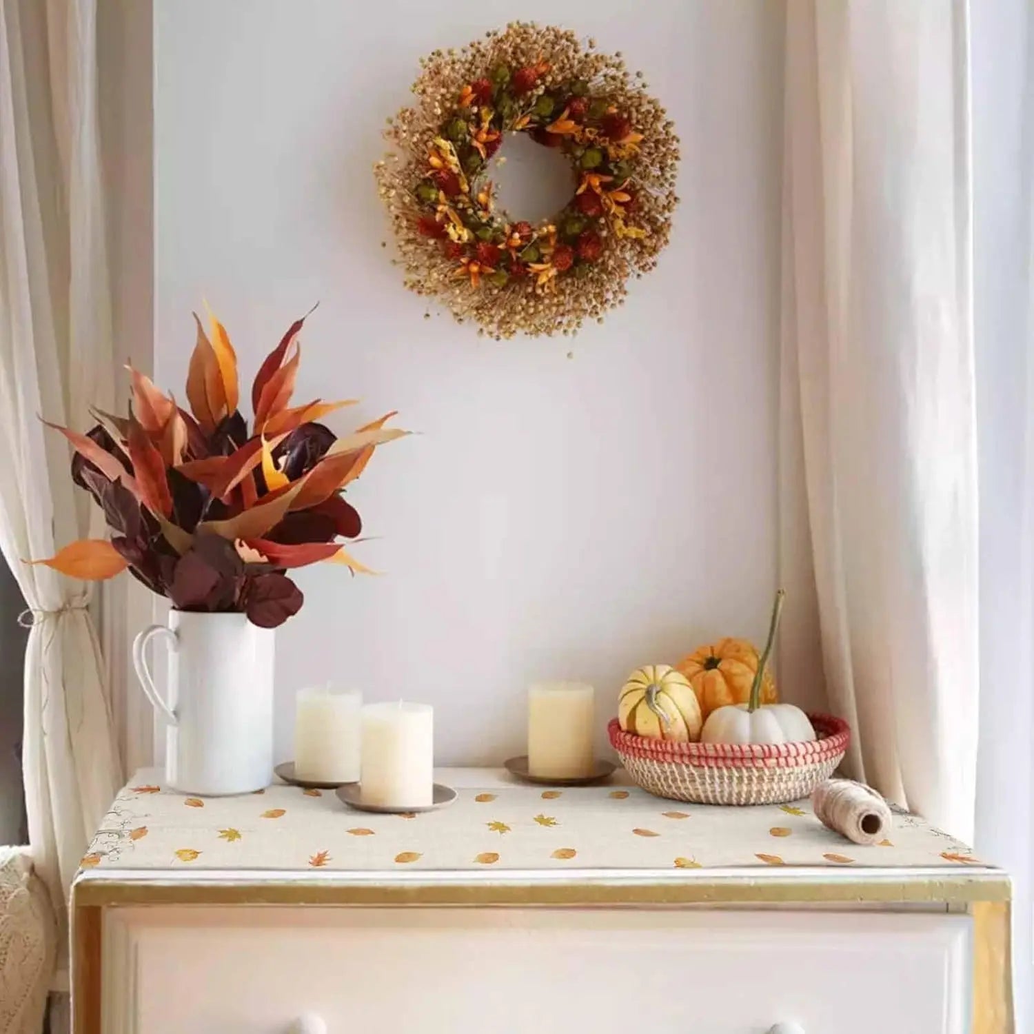 Une belle décoration d'automne composée d'un bouquet de fleurs colorées, d'une couronne de pommes de pin et de citrouilles dans un panier.