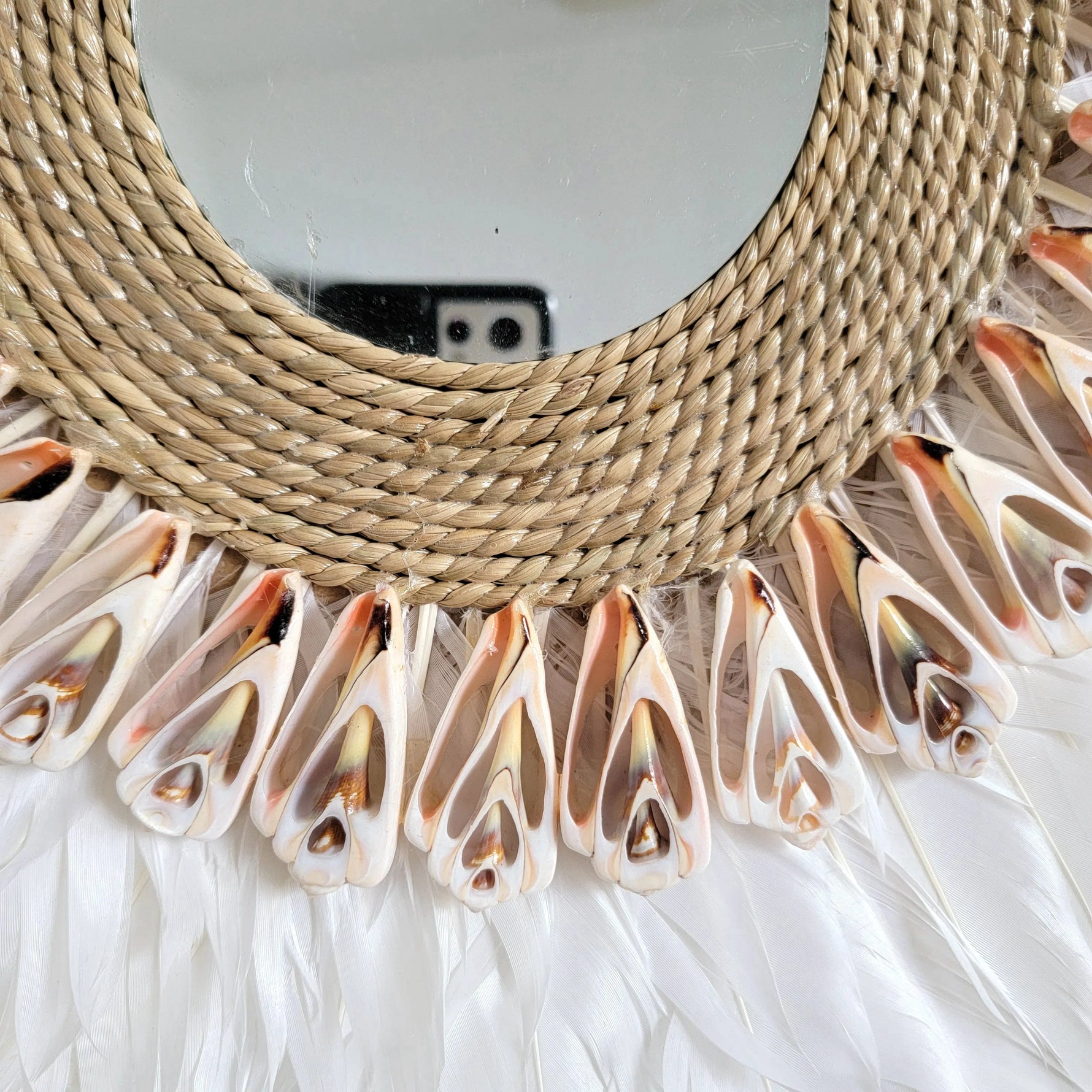 Détail du tressage rotin et plumes du miroir