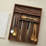 Boîte de rangement en bois noir dans un tiroir de cuisine organisé