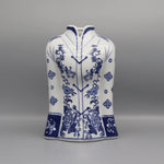 Ce vase décoratif en porcelaine blanche présente un motif floral bleu foncé magnifique, avec des fleurs et des motifs ornementaux élégants répartis sur toute la surface.