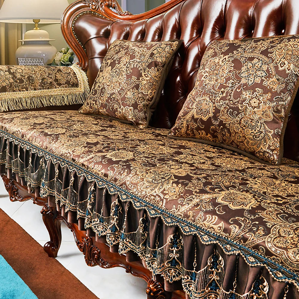 Coussins et draperie ornés de motifs floraux sur un canapé en cuir marron dans un intérieur élégant.