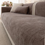 Le canapé confortable en gris foncé avec de nombreux coussins s'intègre harmonieusement dans le décor lumineux.