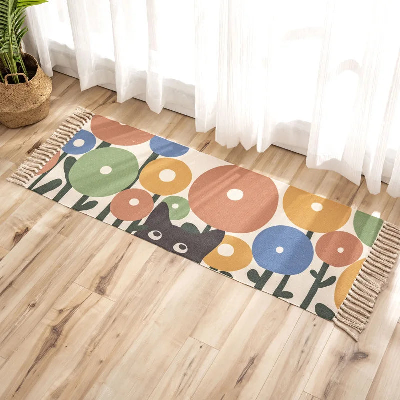 Un tapis coloré et géométrique au sol, avec des formes arrondies et des couleurs vives, dans un intérieur lumineux.