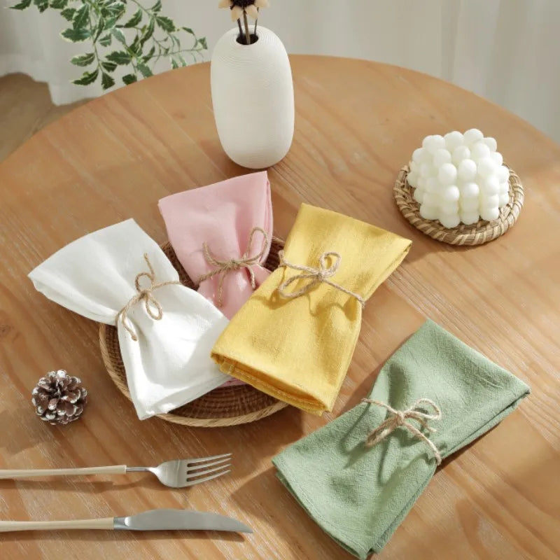 Décor de table élégant avec des serviettes colorées et autres accessoires décoratifs sur une table en bois.