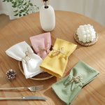 Décor de table élégant avec des serviettes colorées et autres accessoires décoratifs sur une table en bois.