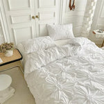 Parure de lit fleurs torsadées tridimensionnelles en beige sur un lit Queen