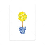 Une belle fleur jaune épanouie dans un vase décoratif bleu et blanc.