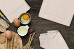 Mise en scène de divers ingrédients et articles de cuisine sur une table en bois, suggérant la préparation d'un repas ou d'un plat.