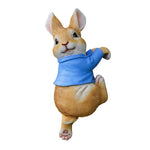 Peluche de lapin mignon avec veste bleue, posée sur fond blanc.
