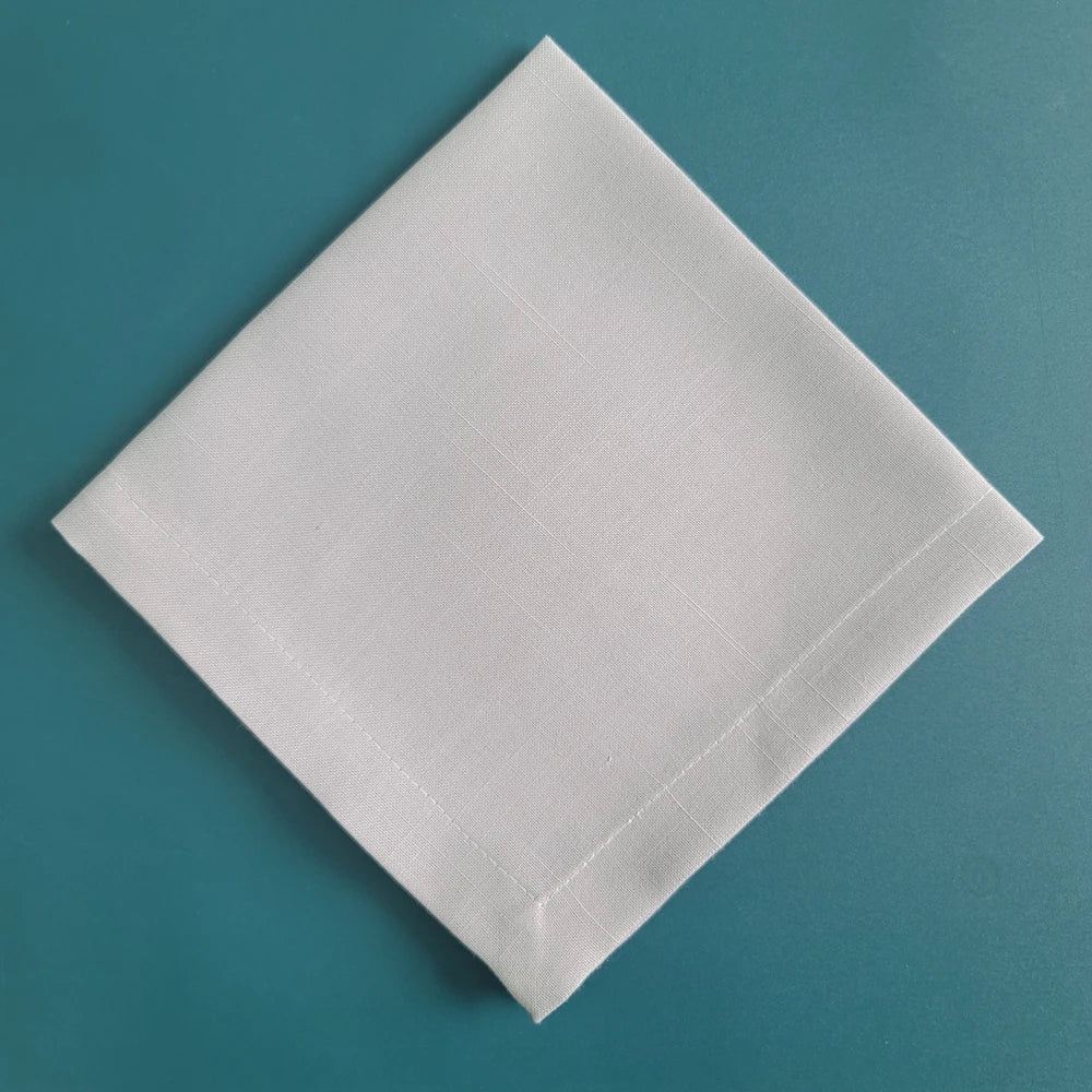 Une dalle blanche rectangulaire repose sur un fond turquoise uniforme.