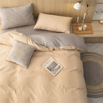 Parure de lit grise disposée sur un lit avec décoration chambre