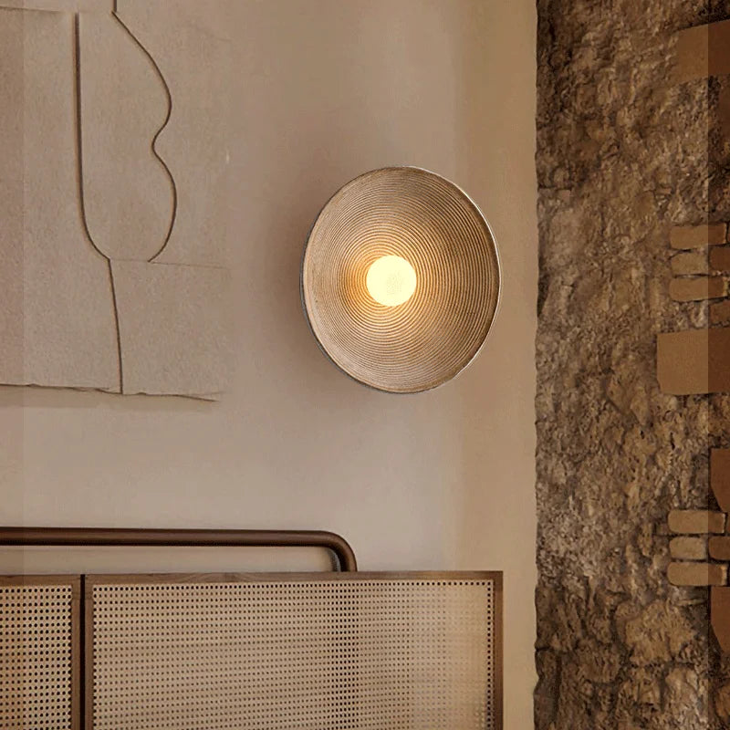 Installation de l'applique murale dans un salon avec ambiance chaleureuse