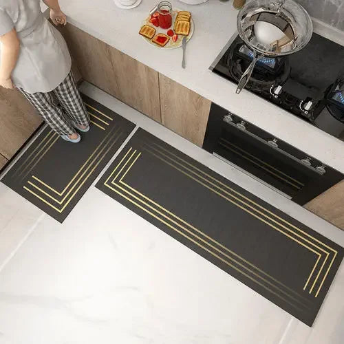 Un plan de travail moderne et élégant avec des lignes dorées sur fond noir, complété par des ustensiles de cuisine et des accessoires dans la cuisine.
