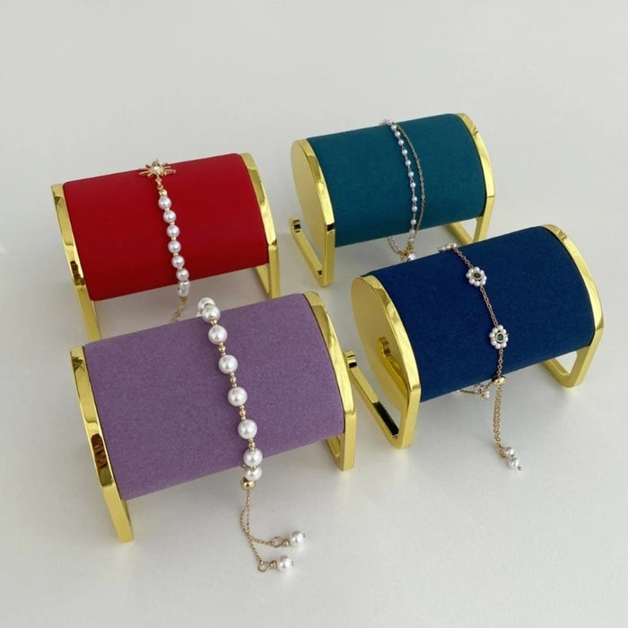 Présentoir bracelets et montres en métal doré sur table de chevet