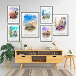 Cette image présente une collection de toiles murales représentant diverses villes et paysages, encadrées et disposées sur un mur blanc, accompagnées d'un meuble de rangement en bois clair, de plantes vertes et d'autres éléments décoratifs, créant une atmosphère chaleureuse et voyageuse dans cette pièce.