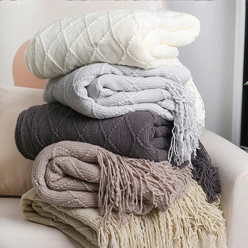 Jeté de canapé utilisé comme couverture au pied d'un lit dans une chambre élégante