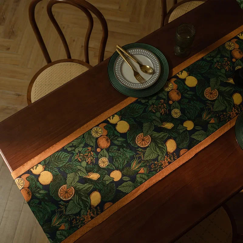 Une jolie nappe ornée de motifs botaniques colorés, mettant en scène un couvert élégant sur une table en bois rustique.