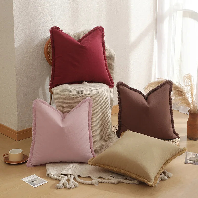 Coussins décoratifs de différentes couleurs et textures disposés dans un salon confortable.