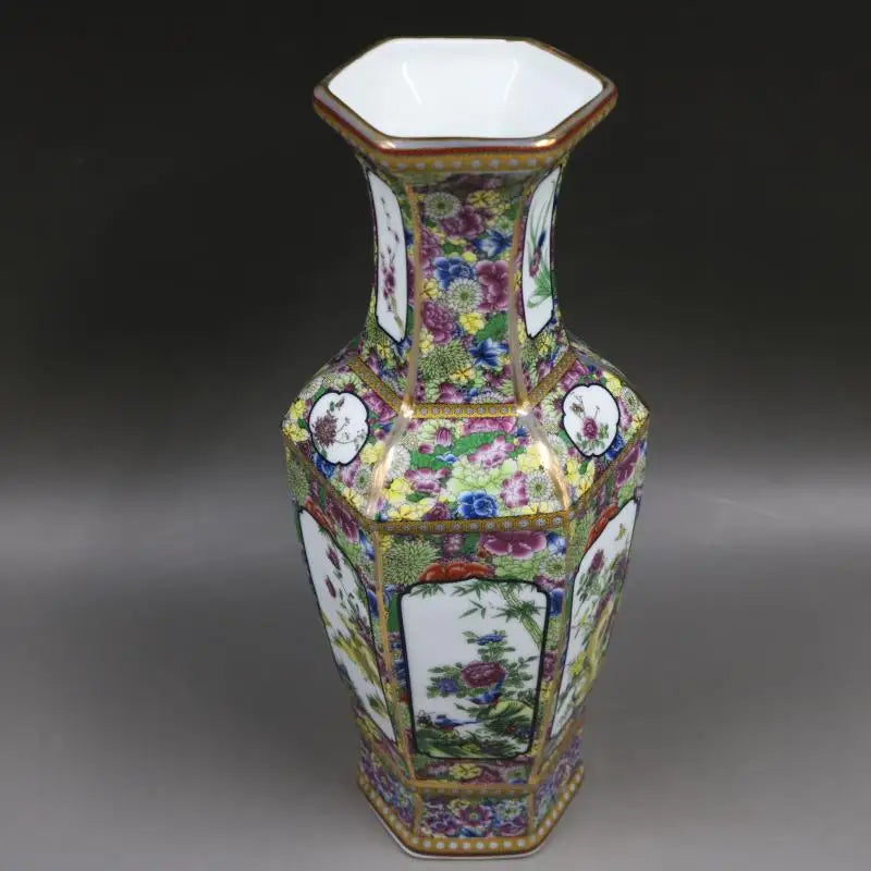 Vase de porcelaine décoré de motifs floraux colorés et de médaillons sur un fond blanc, créant une belle et sophistiquée conception.