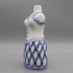 Photographie d'un vase de couleur blanche avec un motif bleu en forme de spirale et de rayures entrecroisées.