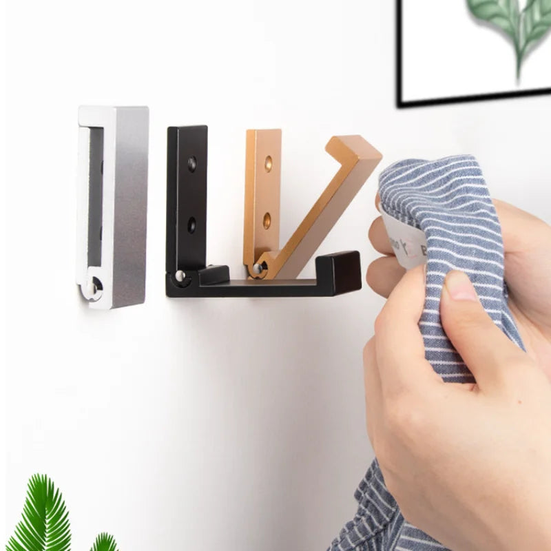 Patère murale pliante sans trou en aluminium noir sur un mur blanc