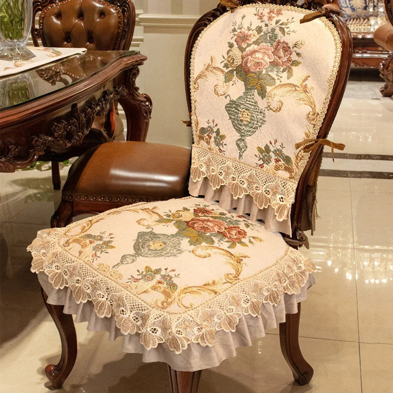Chaise ancienne en bois foncé avec un rembourrage en tapisserie florale délicate, agrémentée de dentelles et de volants pour un style élégant et raffiné.