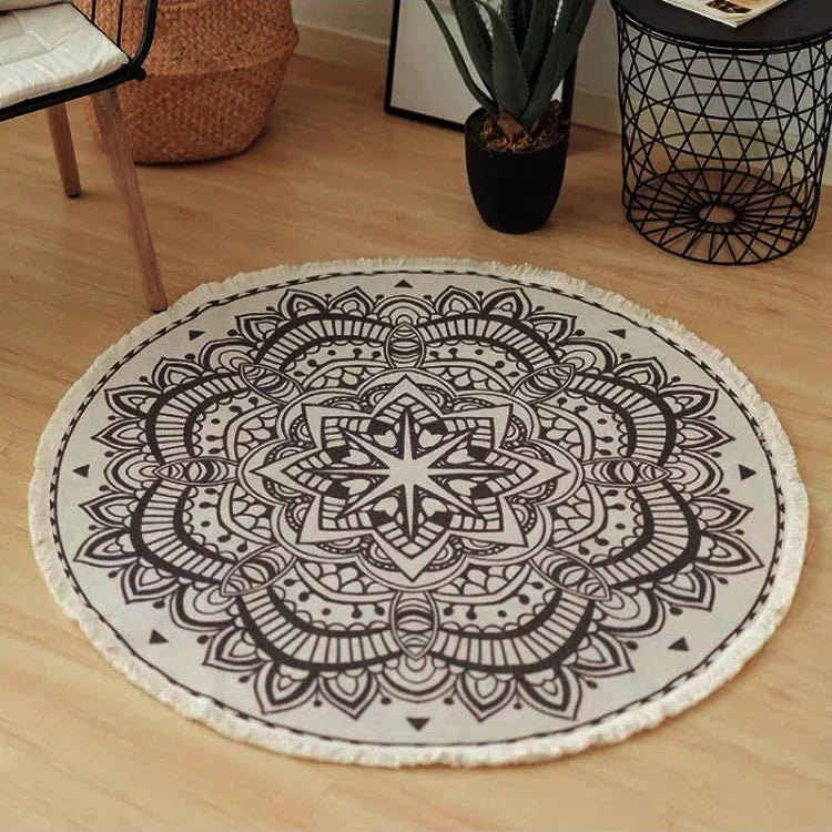 Tapis rond décoratif avec un motif mandala ornemental noir et blanc, posé sur un plancher de bois clair dans un intérieur moderne.