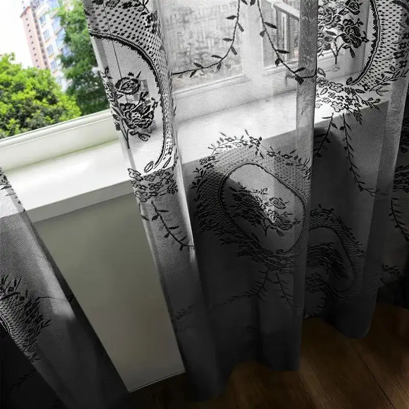Rideau dentelle noire installé dans un salon avec lumière filtrante