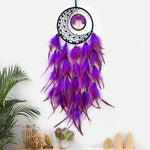 Captivant attrape-rêves violet suspendu avec plumes décoratives dans un décor végétal moderne.