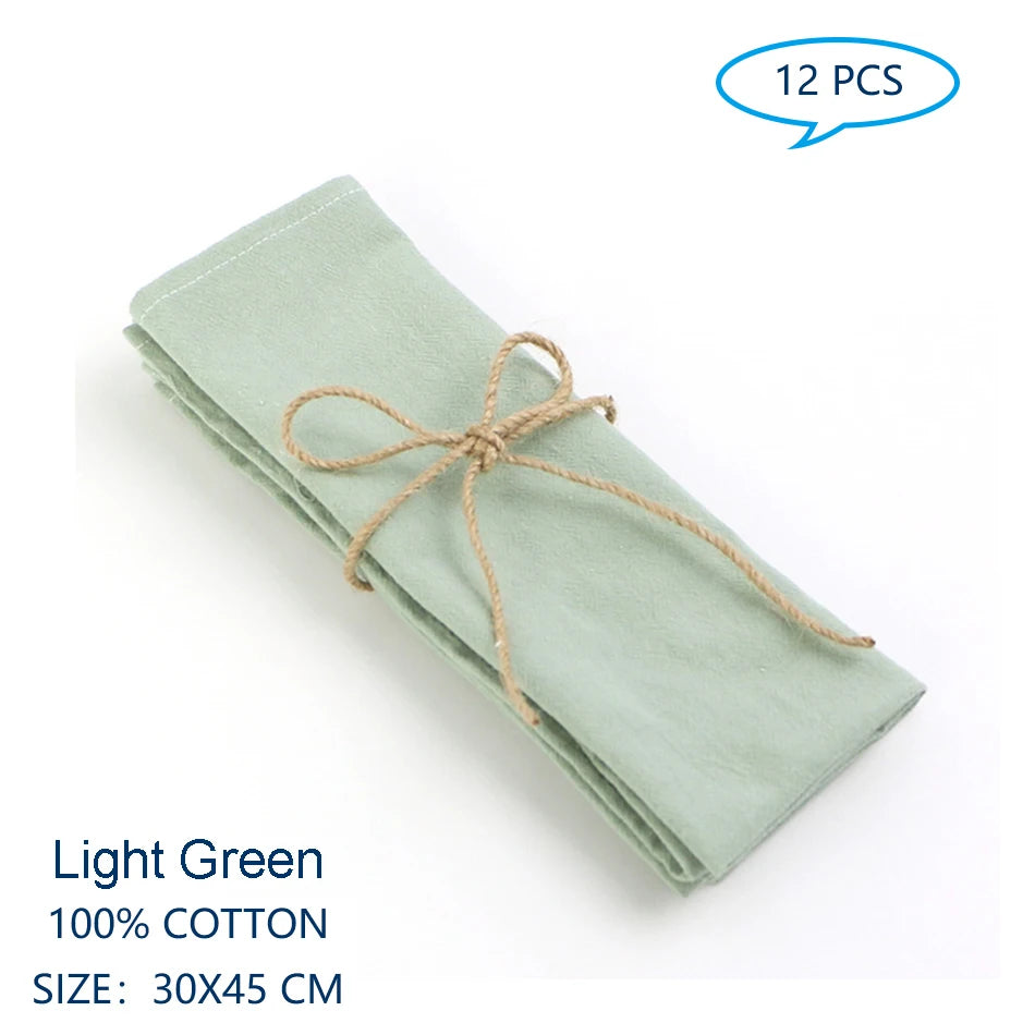 Serviette en coton vert clair de 30x45 cm, pliée et attachée avec une ficelle.