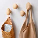 Patère murale design galet en bois gris clair sur porte