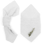 Un ensemble de serviettes de bain blanches luxueuses, avec une décoration naturelle subtile d'une brindille de romarin.