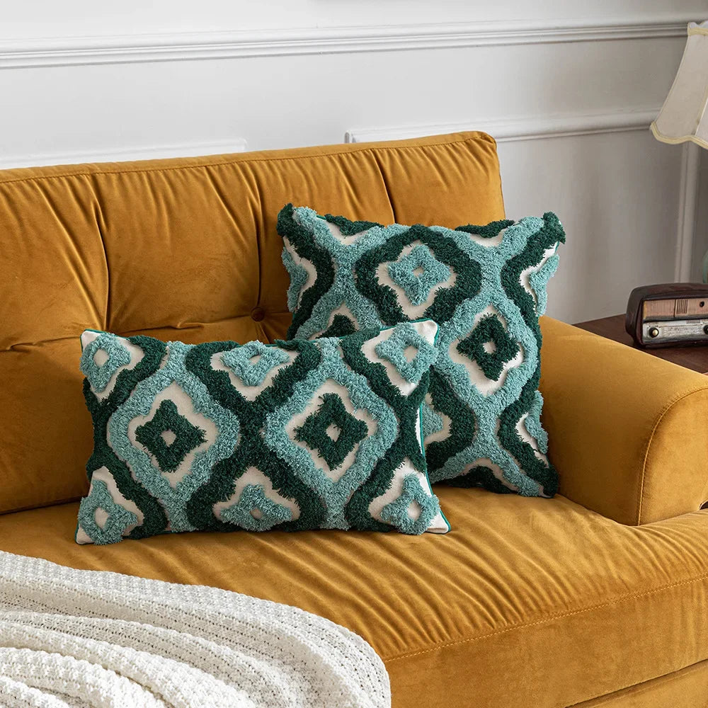 Des coussins décoratifs avec un motif géométrique texturé sur un canapé en velours ocre dans un salon.