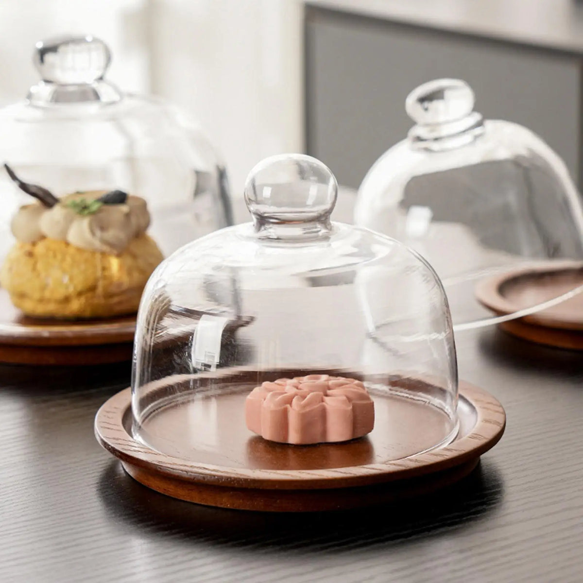 Plateau à gâteaux avec dôme en verre présentant des desserts
