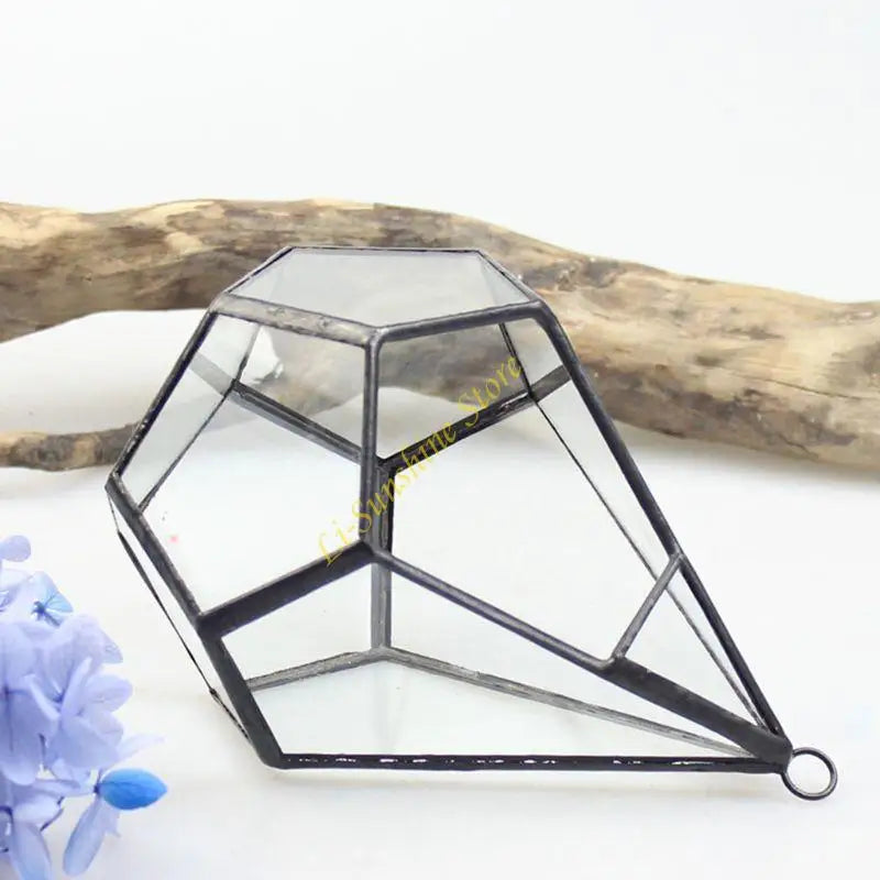 Terrarium pyramide noir utilisé comme présentoir pour objets décoratifs