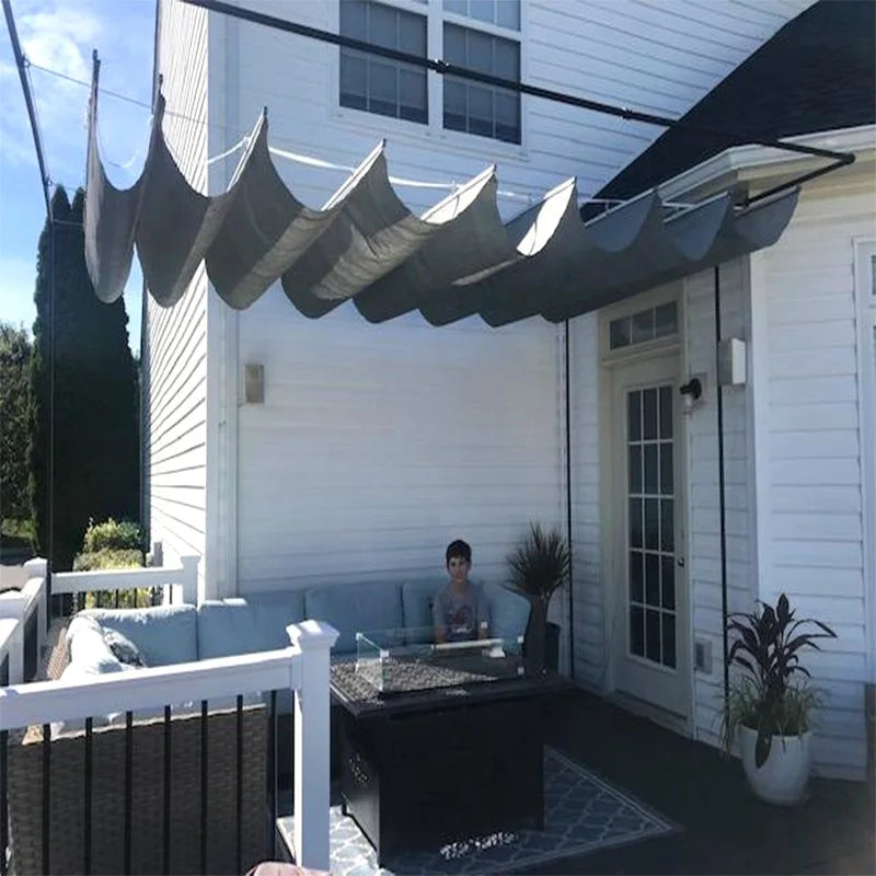 Voile d'ombrage rétractable blanche protégeant un coin salon de jardin
